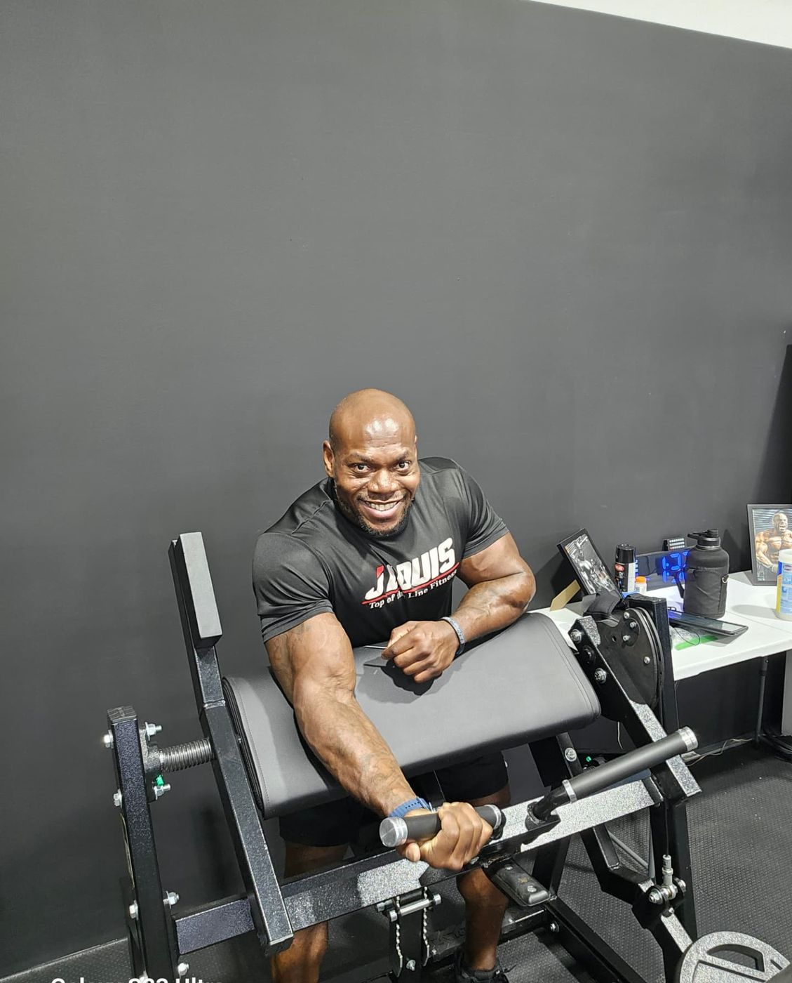 Josh Louis training at the preacher curl bench in his private gym